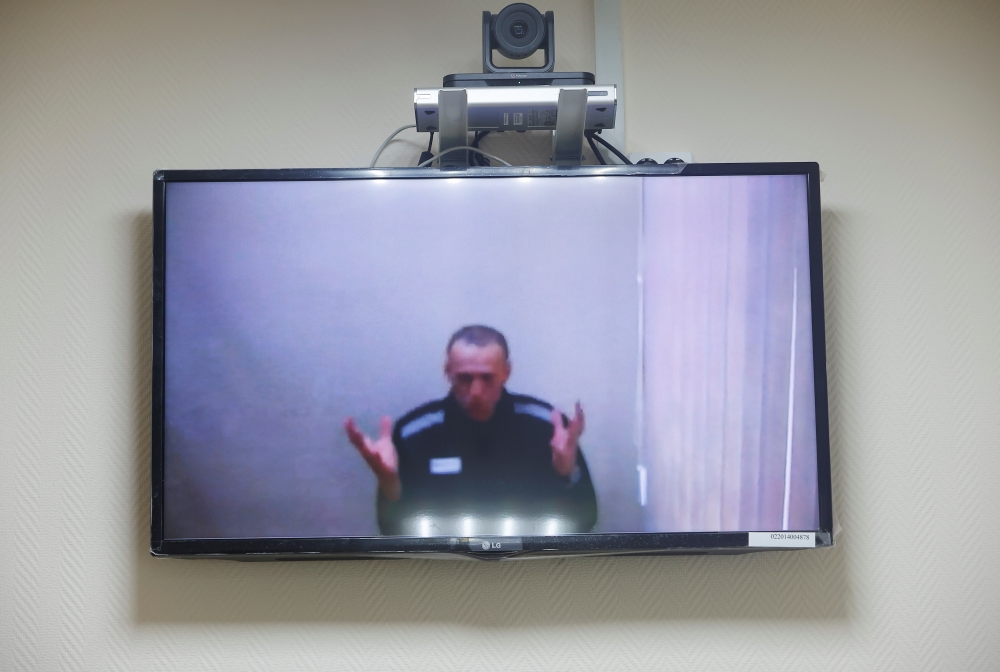 Russian opposition leader Alexei Navalny is seen on a screen via a video link during a hearing to consider his lawsuits against the penal colony over detention conditions there, at the Petushki district court in Petushki, Russia May 26, 2021. REUTERS/Maxi