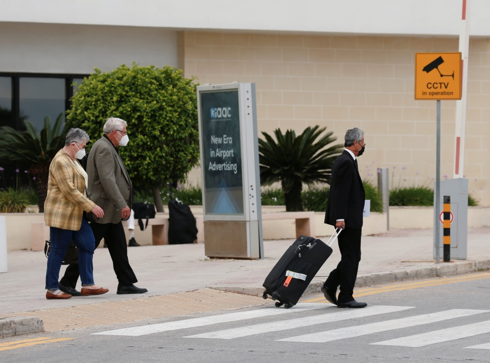 A taxi driver helps tourists with their luggage outside the arrivals terminal amid the coronavirus disease pandemic, as Malta officially restarted its tourism season. Reuters/Darrin Zammit Lupi