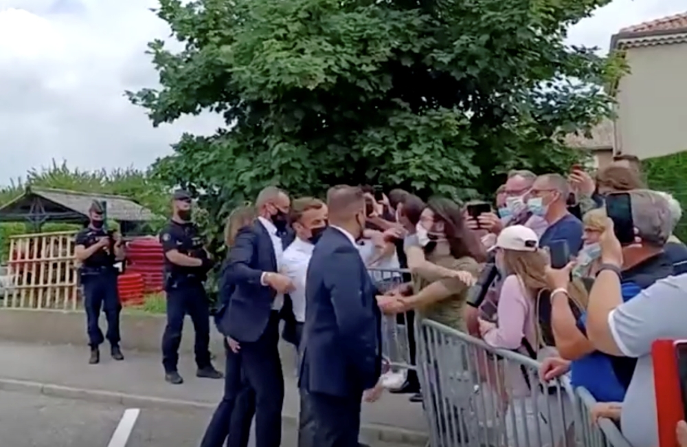 French President Emmanuel Macron gets slapped by a member of the public during a visit in Tain-L'Hermitage, France, in this still image taken from video on June 8, 2021. BFMTV/ReutersTV