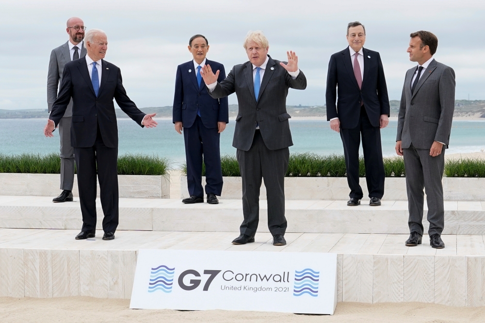 U.S. President Joe Biden and British Prime Minister Boris Johnson gesture as they pose for a family photo with G-7 leaders; European Council President Charles Michel, Japan's Prime Minister Yoshihide Suga, Italy's Prime Minister Mario Draghi and French Pr