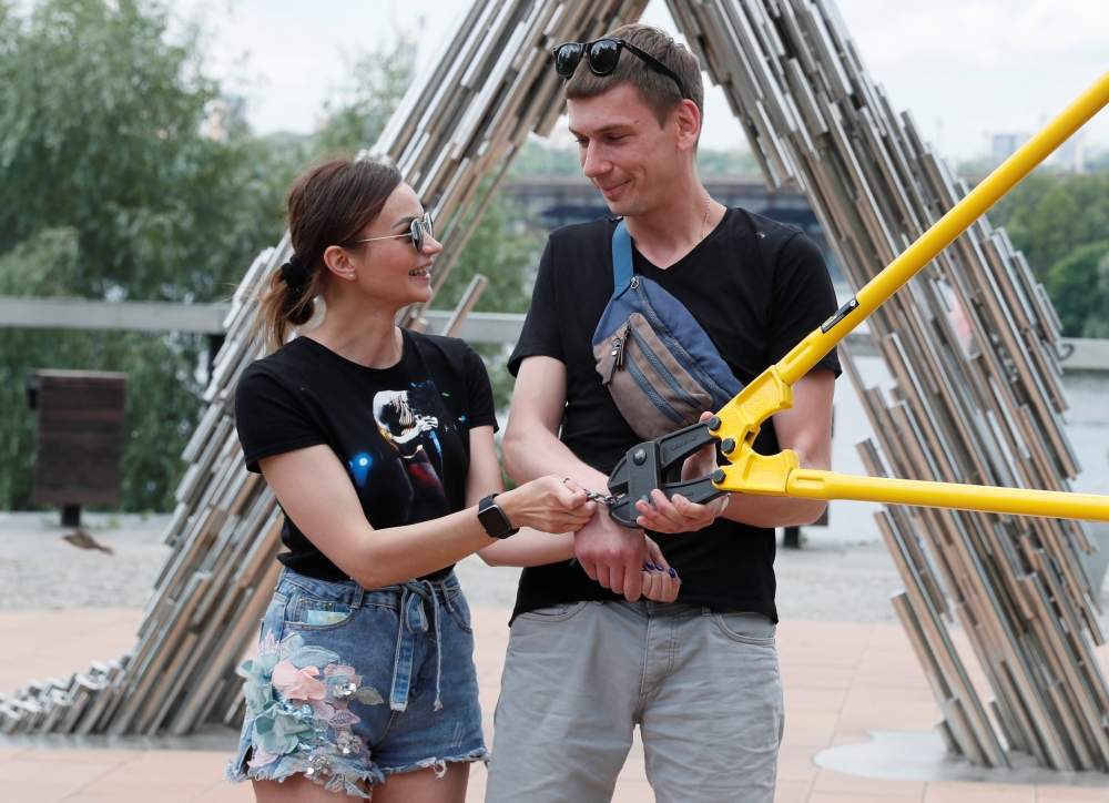 Alexandr Kudlay and Viktoria Pustovitova have the chain dismantled by a representative from a Ukrainian record book in Kyiv, Ukraine June 17, 2021. REUTERS/Gleb Garanich
