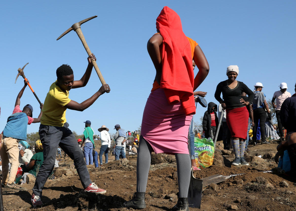 A person uses a pickaxe to dig as fortune seekers flock to the village after pictures and videos were shared on social media showing people celebrating after finding what they believe to be diamonds, in the village of KwaHlathi, outside Ladysmith, in KwaZ