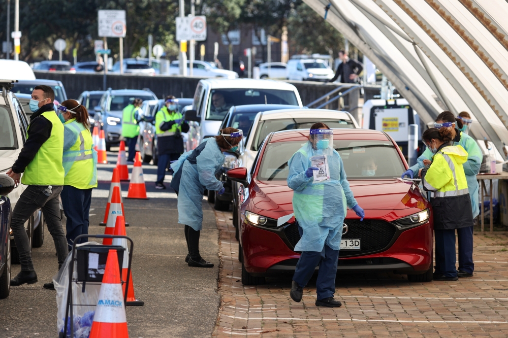 Medical workers administer tests at the Bondi Beach drive-through coronavirus disease (COVID-19) testing centre in the wake of new positive cases in Sydney, Australia, June 17, 2021. REUTERS/Loren Elliott