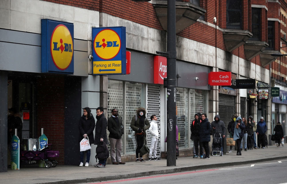 People queue outside Lidl supermarket in Streatham, as the spread of the coronavirus disease (COVID-19) continues, London, Britain, March 29, 2020. (REUTERS/Hannah McKay/File Photo)