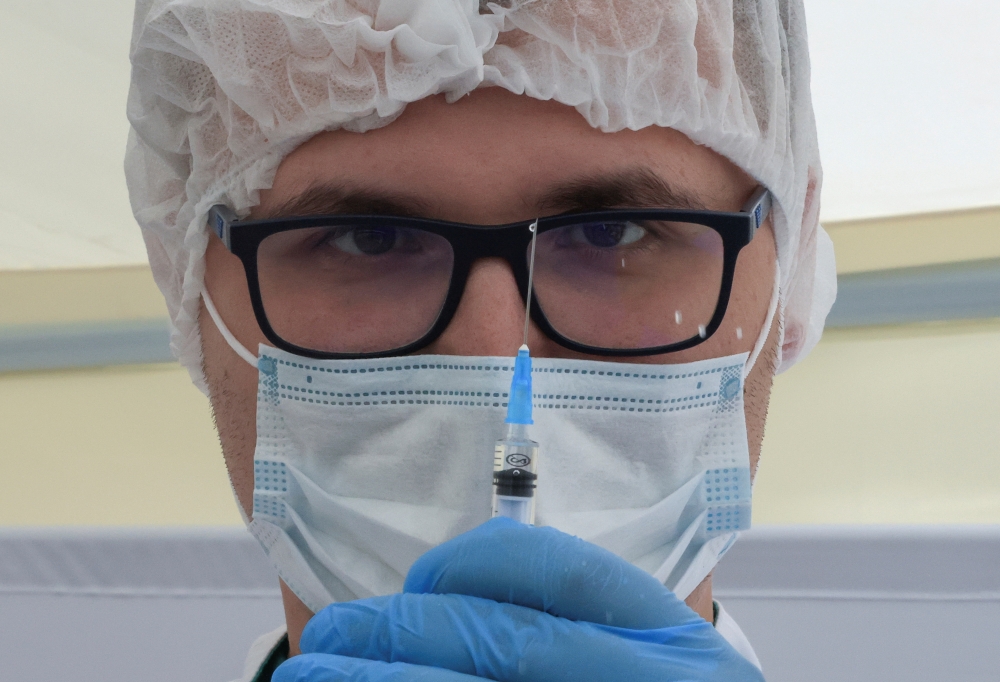 FILE PHOTO: A healthcare worker holds a syringe with the one-dose Sputnik Light vaccine against the coronavirus disease (COVID-19) in a vaccination centre at a city market in Moscow, Russia, June 30, 2021. REUTERS/Tatyana Makeyeva