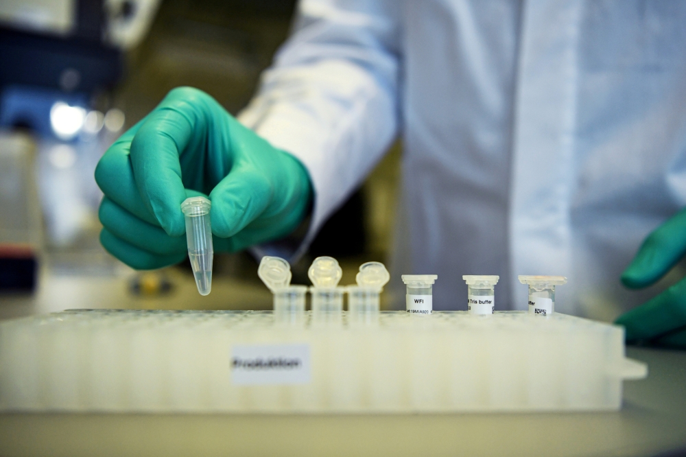 An employee of German biopharmaceutical company CureVac, demonstrates research workflow on a vaccine for the coronavirus (COVID-19) disease at a laboratory in Tuebingen, Germany, March 12, 2020. REUTERS/Andreas Gebert/File Photo