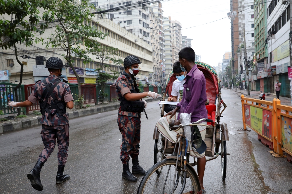 Members of Border Guard Bangladesh (BGB) check commuters at a checkpost during a countrywide lockdown in Dhaka, Bangladesh, July 1, 2021. REUTERS/Mohammad Ponir Hossain