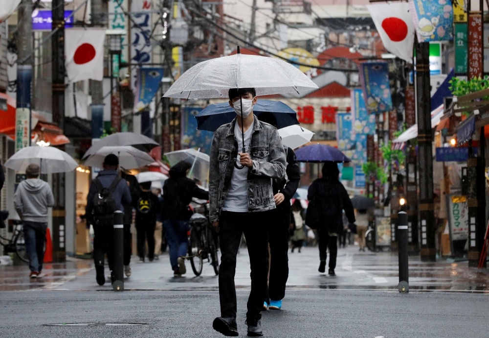 A man wearing a protective face mask, amid the coronavirus disease (COVID-19) pandemic, makes his way at a local shopping street in Tokyo, Japan, May 5, 2021. REUTERS/Kim Kyung-Hoon/File Photo