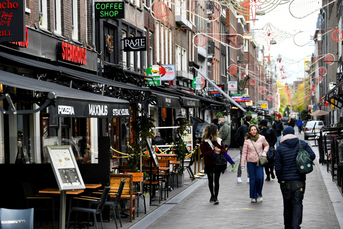 FILE PHOTO: People walk past restaurants and bars as the Netherlands battles to control the spread of the coronavirus disease (COVID-19), in Amsterdam, Netherlands October 14 2020. REUTERS/Piroschka van de Wouw/File Photo/File Photo
