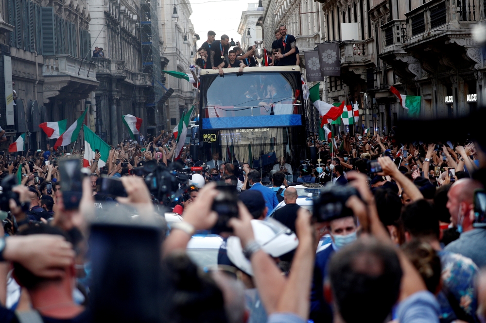 FILE PHOTO: Soccer Football - Euros 2020 - The Italy team drive through Rome on a open top bus tour amidst celebrating fans after winning the Euros 2020, July 12, 2021. REUTERS/Guglielmo Mangiapane/File Photo
