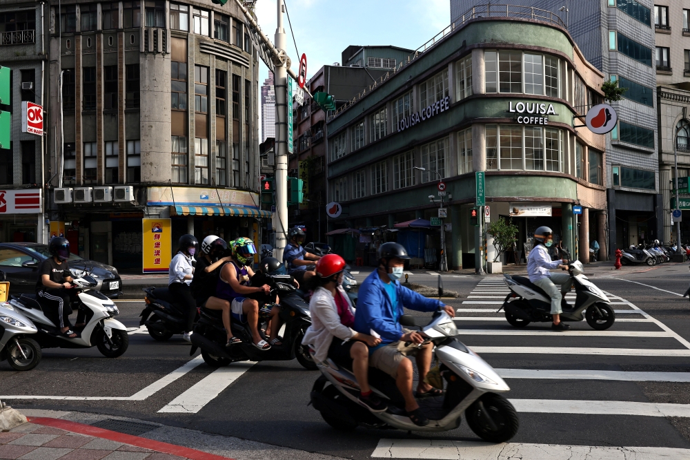 People wearing masks drive motorbikes in Taipei amid the Coronavirus disease (Covid-19) in Taiwan, June 30, 2021. REUTERS/Ann Wang/File Photo