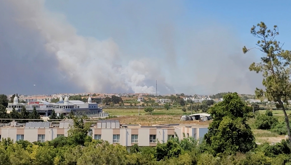 Smoke from a wildfire is seen in Manavgat, Antalya, Turkey July 28, 2021 in this still image taken from social media video. TWITTER/@ONURBURAKCELIK/via REUTERS