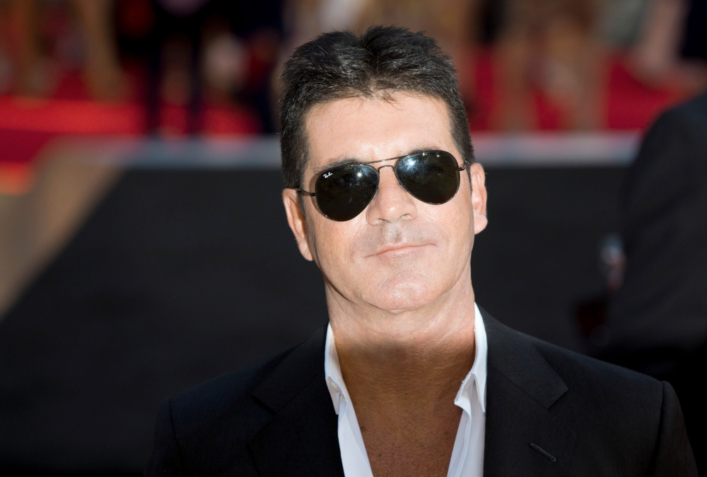 Television mogul Simon Cowell poses for photographers as he arrives for the film 