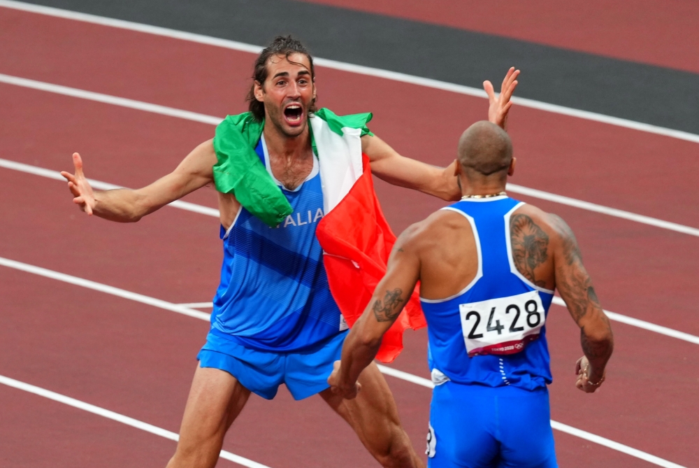 Lamont Marcell Jacobs of Italy celebrates after winning gold with Gianmarco Tamberi of Italy REUTERS/Aleksandra Szmigiel