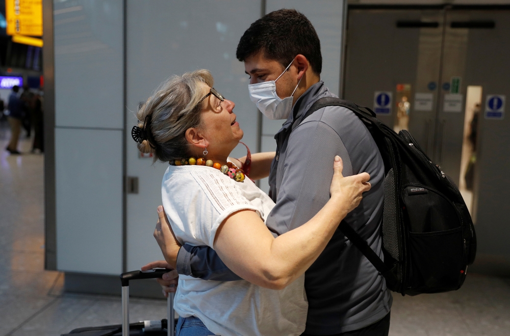 Karen Tyler embraces her son Jonathan who arrived from the U.S., at the International arrivals area of Terminal 5 in London's Heathrow Airport, Britain, August 2, 2021. Reuters/Peter Nicholls
