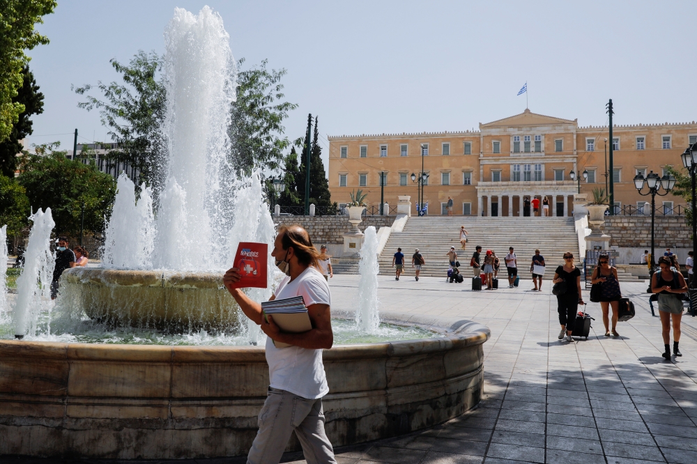 People make their way to Syntagma square during a heatwave in Athens, Greece, August 2, 2021. REUTERS/Costas Baltas