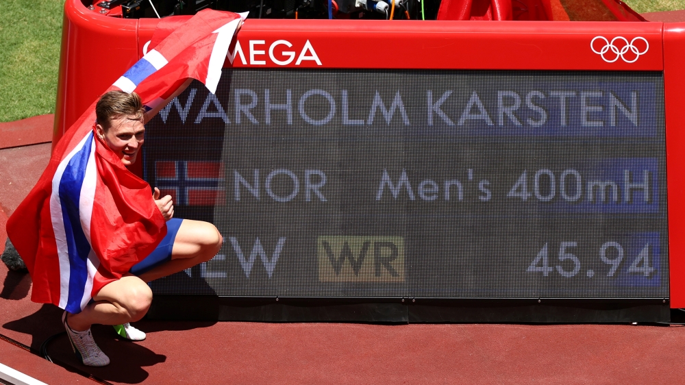  Karsten Warholm of Norway poses next to his new world record as he celebrates after winning gold. Reuters/Andrew Boyers
