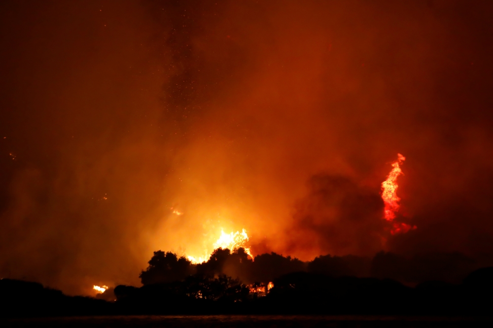 Night sky turns orange as Turkey's wildfires rage on at the shores of Cokertme village near Bodrum, Turkey, August 2, 2021. REUTERS/Umit Bektas
