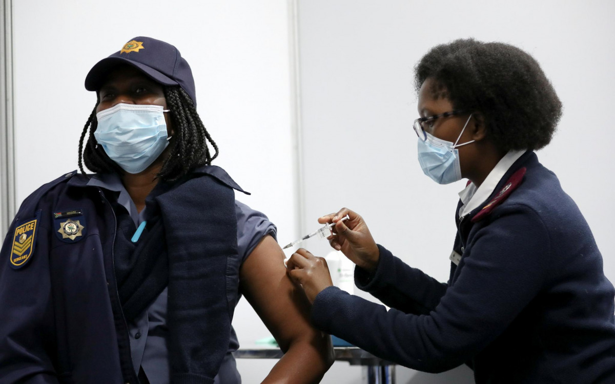 FILE PHOTO: Thelma Modise, a member of the South African Police Service (SAPS) receives a dose of a coronavirus disease (COVID-19) vaccine as part of a vaccine rollout to over 180,000 SAPS members, in the township of Soweto, South Africa July 5, 2021. REU