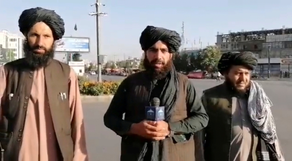 A man holds a wireless microphone as he speaks on the street in Kabul, Afghanistan, in this still image taken from social media video uploaded August 16, 2021.