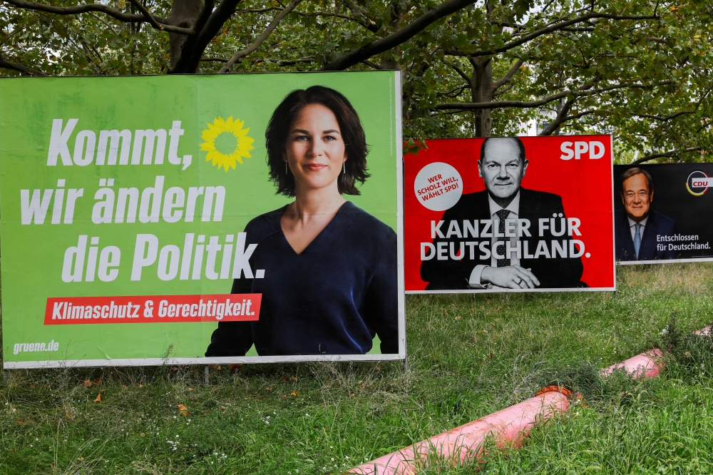 Election campaign billboards featuring the three top candidates for the German chancellery (the Greens' Annalena Baerbock, SPD's Olaf Scholz and CDU's Armin Laschet) stand on a roadside in Berlin, Germany, September 10, 2021. Reuters/Michele Tantussi/File