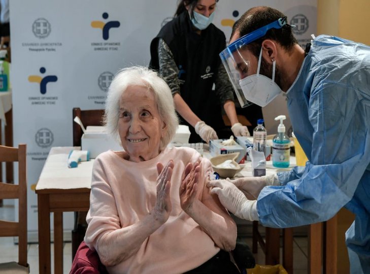 FILE PHOTO: An elderly woman claps her hands after receiving a vaccine against the coronavirus at a nursing home in Athens, Greece, January 25, 2021/REUTERS
