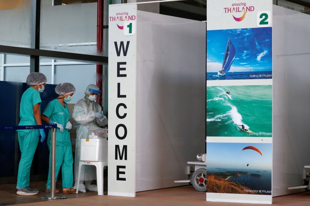 Health workers stand at the COVID-19 swab test area at the airport as Phuket reopens to overseas tourists, allowing foreigners fully vaccinated against the coronavirus disease (COVID-19) to visit the resort island without quarantine, in Phuket, Thailand J