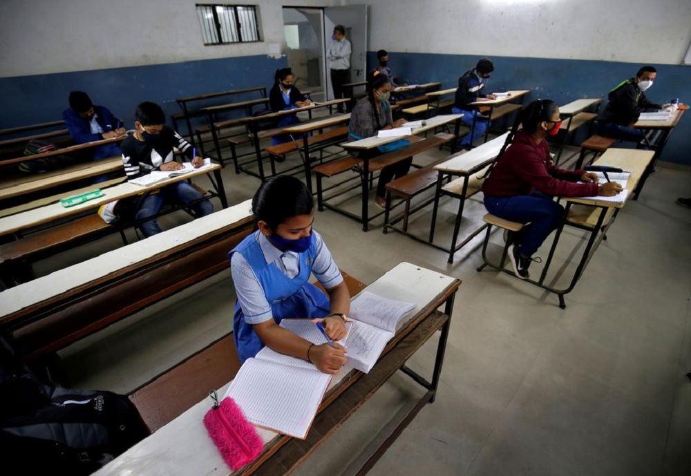 Students wearing protective face masks attend their class as they maintain social distancing after authorities reopened schools for classes for 10 and 12 after the schools were closed for months due to the coronavirus disease (COVID-19) outbreak, in Ahmed