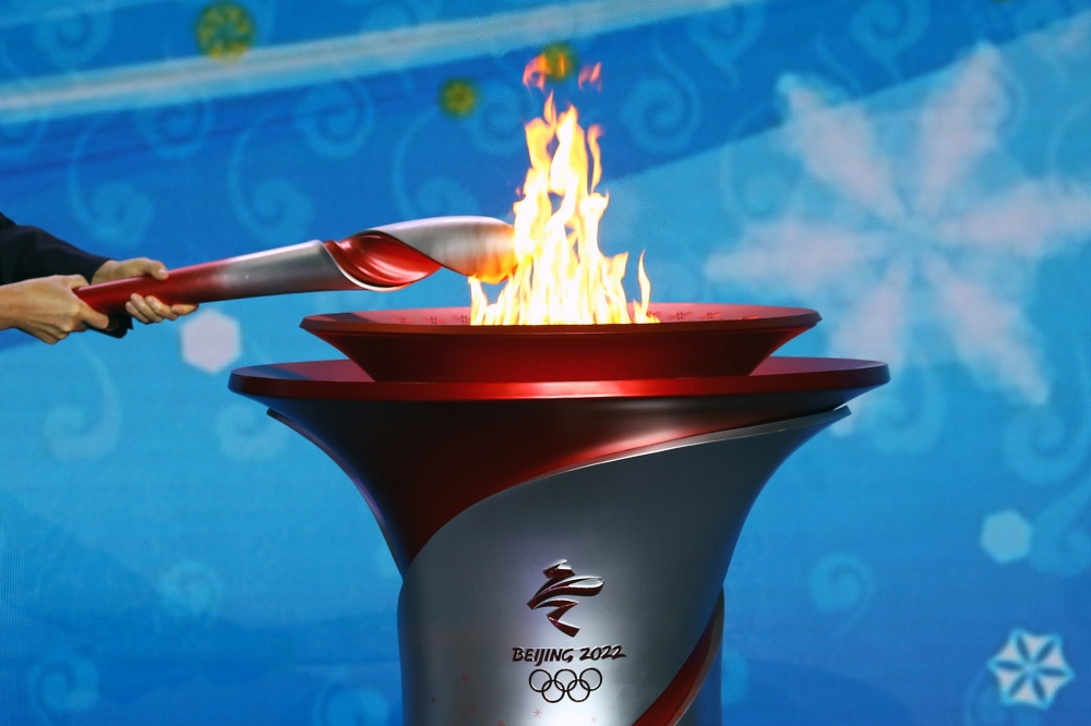 Beijing Communist Party Secretary and President of the Beijing 2022 Organising Committee Cai Qi transfers the Olympic flame to a cauldron at the ceremony to welcome the flame for the Beijing 2022 Winter Olympics, in Beijing, China October 20, 2021. REUTER