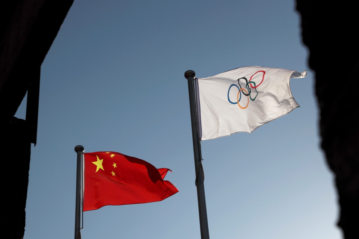FILE PHOTO: The Chinese and Olympic flags flutter at the headquarters of the Beijing Organising Committee for the 2022 Olympic and Paralympic Winter Games in Beijing, China November 12, 2021. REUTERS/Thomas Suen/File Photo
