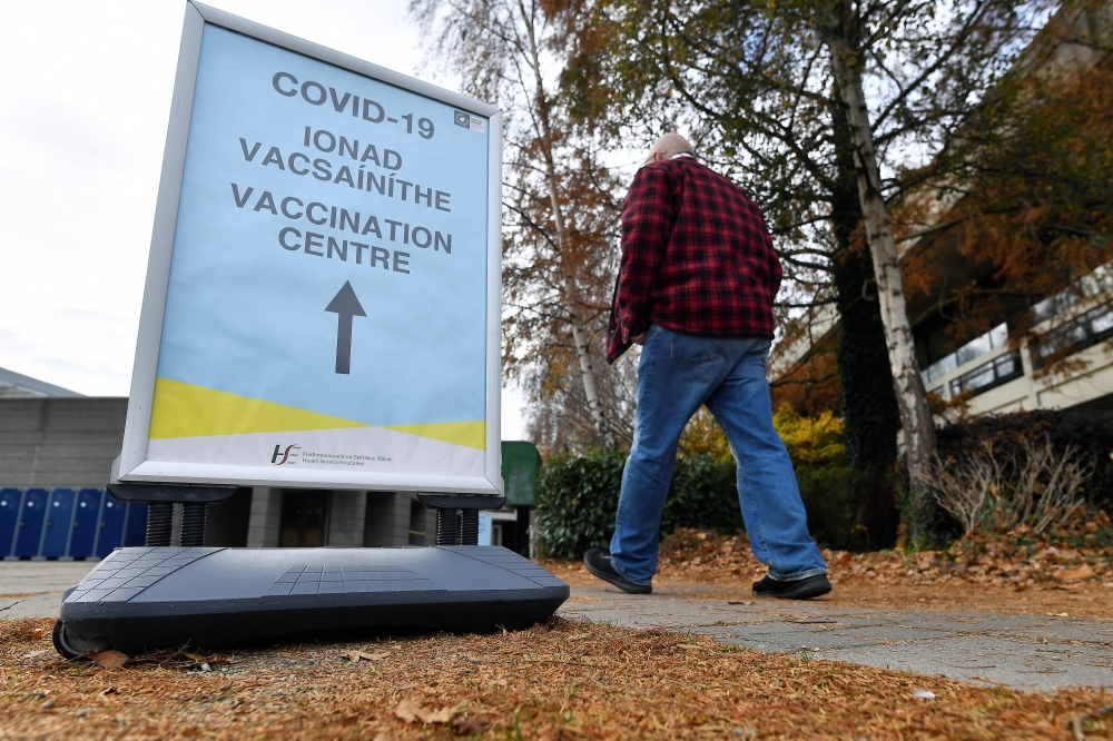 A man walks past a sign for the coronavirus disease (COVID-19) vaccination centre at University College Dublin (UCD) campus clinic for inoculating frontline workers in Dublin, Ireland, November 28, 2021. Reuters/Clodagh Kilcoyne