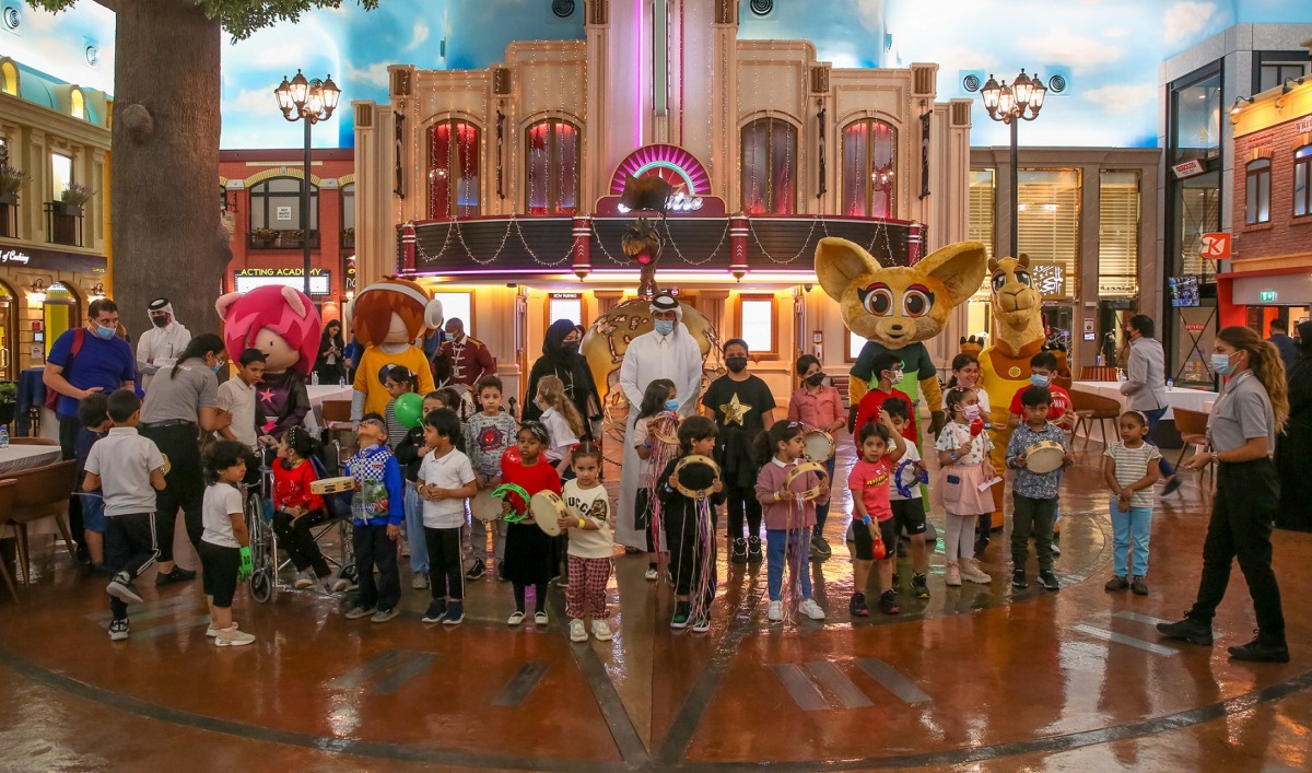 Officials with children celebrating fun day at KidZania Doha.
