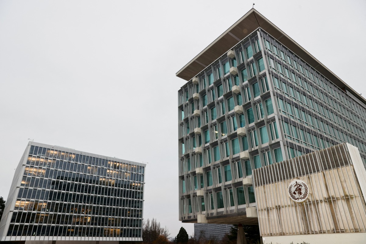 FILE PHOTO: The World Health Organization logo is pictured outside the old and the new WHO buildings, in Geneva, Switzerland, December 20, 2021. REUTERS/Denis Balibouse/File Photo

