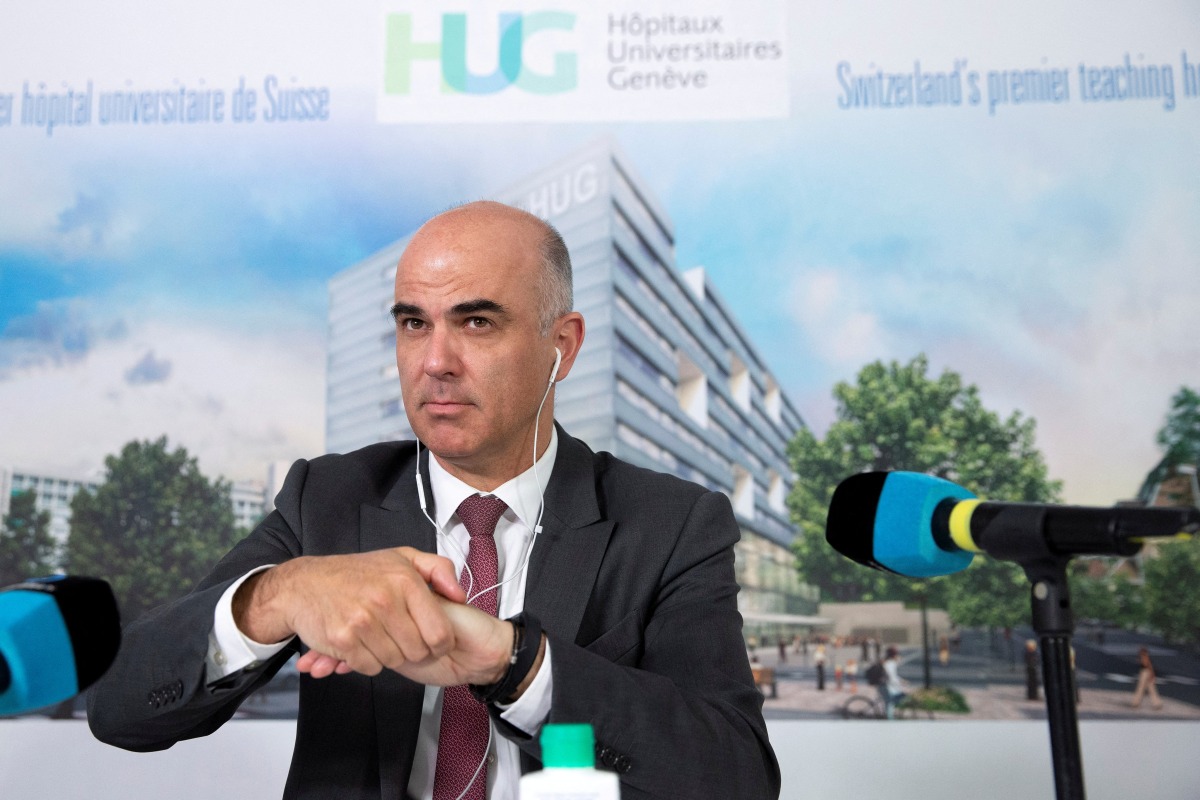 FILE PHOTO: Swiss Interior Minister Alain Berset cleans his hands before a news conference on the coronavirus disease (COVID-19) outbreak, after meeting with the HUG's medical staff and visiting the emergency department, at the Geneva University Hospitals (HUG), in Geneva, Switzerland, March 24, 2020. Salvatore Di Nolfi/Pool via REUTERS/File Photo
