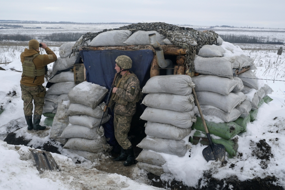 Service members of the Ukrainian armed forces stand guard at combat positions on the line of separation from Russian-backed rebels outside the settlement of Krymske in the Luhansk region, Ukraine, January 4, 2022. REUTERS/Maksim Levin