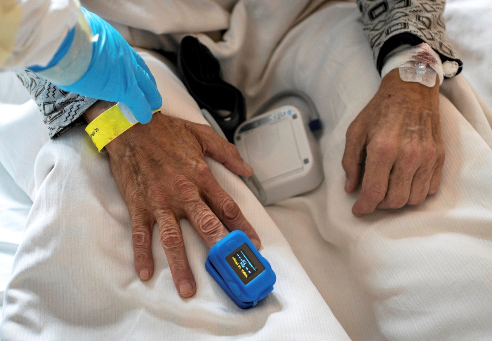 A medical specialist treats a patient in a ward for people suffering from the coronavirus disease (COVID-19) at a city hospital in Gliwice, Poland, December 2, 2021. Picture taken December 2, 2021. Grzegorz Celejewski/Agencja Wyborcza.pl via REUTERS