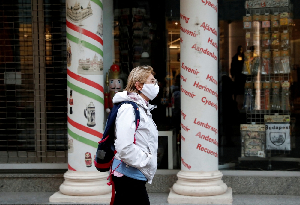 A woman wearing a protective face mask walks in downtown Budapest, after Hungarian government imposed a nationwide lockdown to contain the spread of the coronavirus disease (COVID-19), Hungary, November 11, 2020. REUTERS/Bernadett Szabo/File Photo