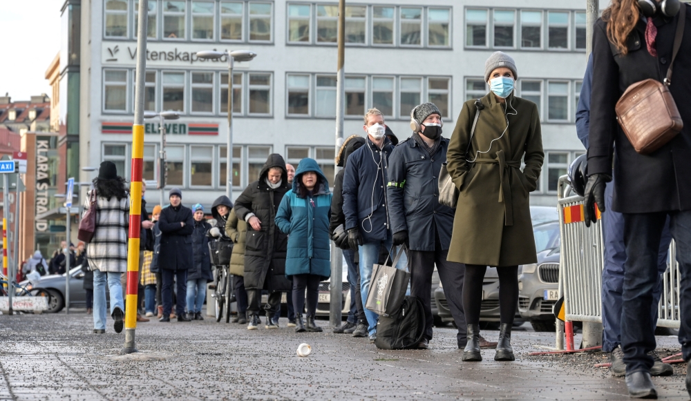 People queue for a drop-in COVID-19 vaccination at Stockholm City Terminal station, Sweden January 13, 2022. TT News Agency/Anders Wiklund via REUTERS