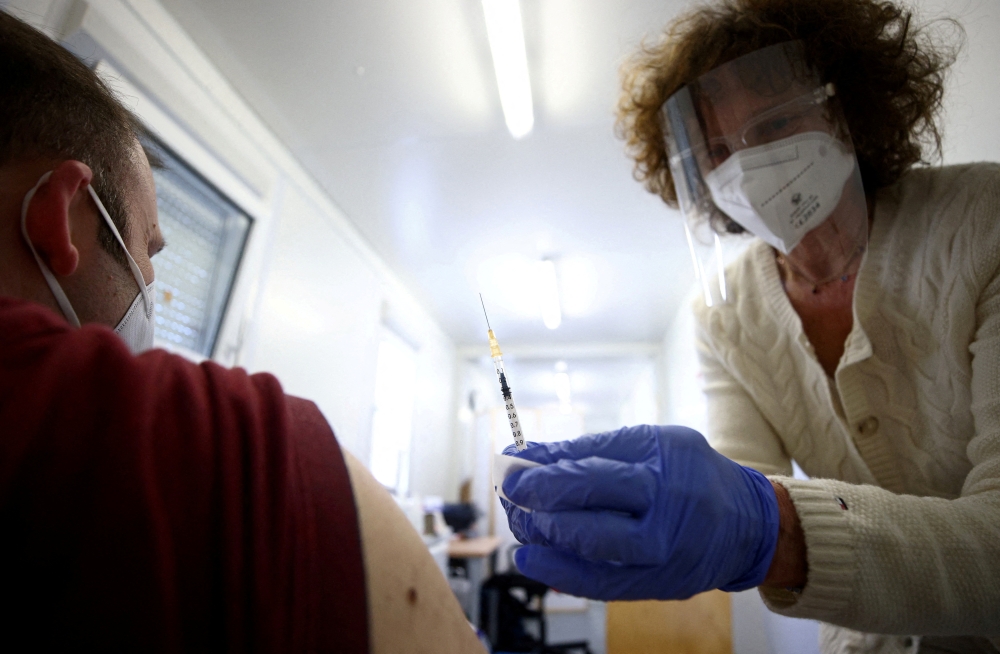  A doctor vaccinates a person with a dose of the Pfizer-BioNTech COVID-19 vaccine in Vienna, Austria April 26, 2021. REUTERS/Lisi Niesner/File Photo