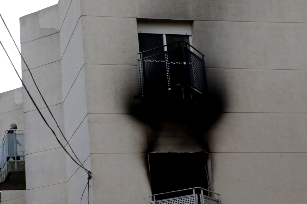 A member of the emergency services works at the scene where a fire ripped through a retirement home in Moncada, Spain, January 19, 2022. REUTERS/Eva Manez