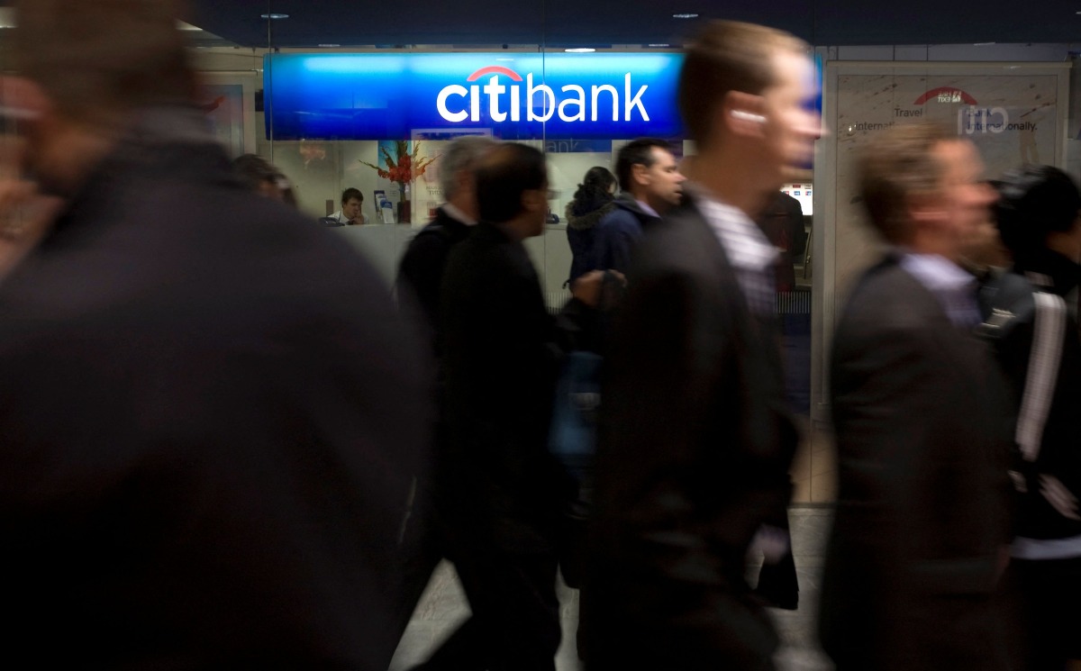 FILE PHOTO: People walk past a Citibank branch during the lunchtime rush in London's financial district of Canary Wharf November 18, 2008. Citigroup Inc revealed plans to cut 52,000 jobs by early next year in a dramatic move to restore the No. 2 U.S. bank to health as it combats mounting debt losses and sagging economies worldwide. REUTERS/Kevin Coombs/File Photo
