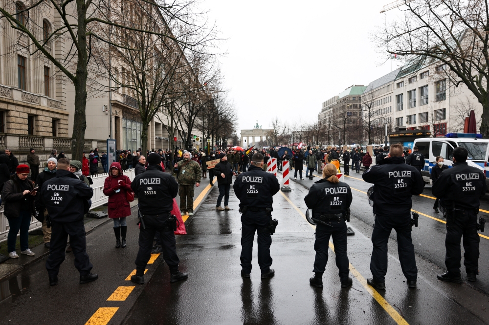 Police officers stand guars while demonstrators protest near of the Reichstag building as the German parliament debates mandatory coronavirus disease (COVID-19) vaccinations, in Berlin, Germany, January 26, 2022. REUTERS/Christian Mang
