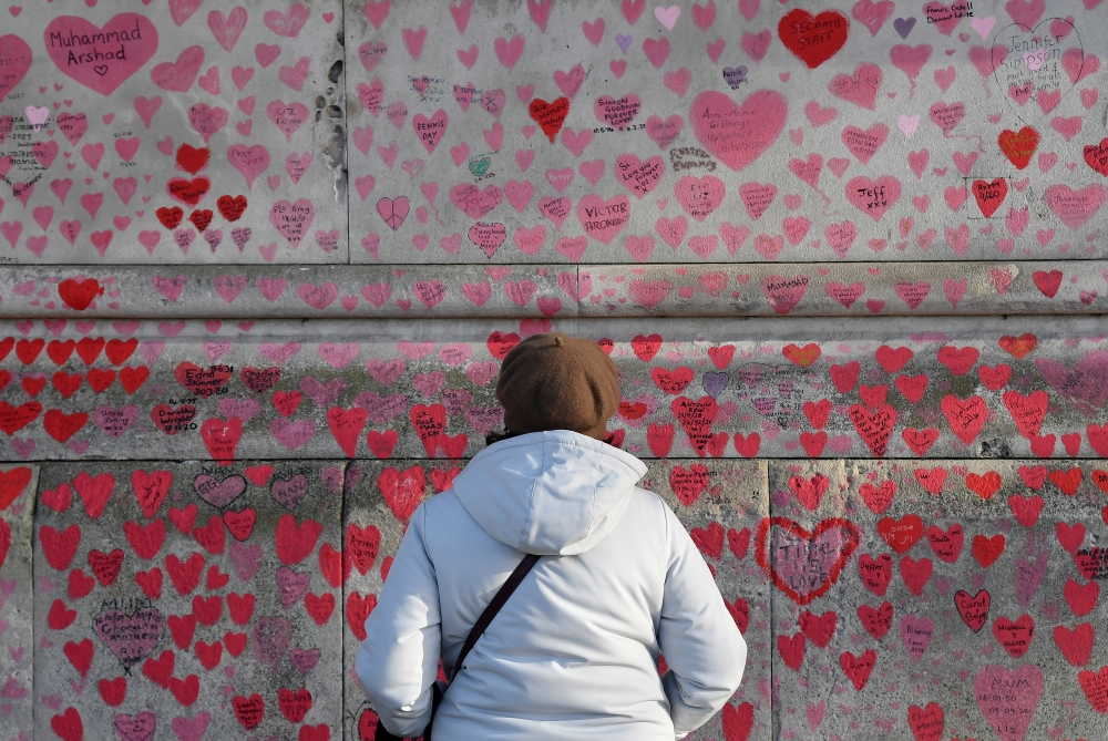 File photo: A woman views the National Covid Memorial Wall, a dedication of thousands of hand-painted hearts and messages for those in the UK who have died from COVID-19, in London, Britain, January 9, 2022. Reuters/Toby Melville/File Photo