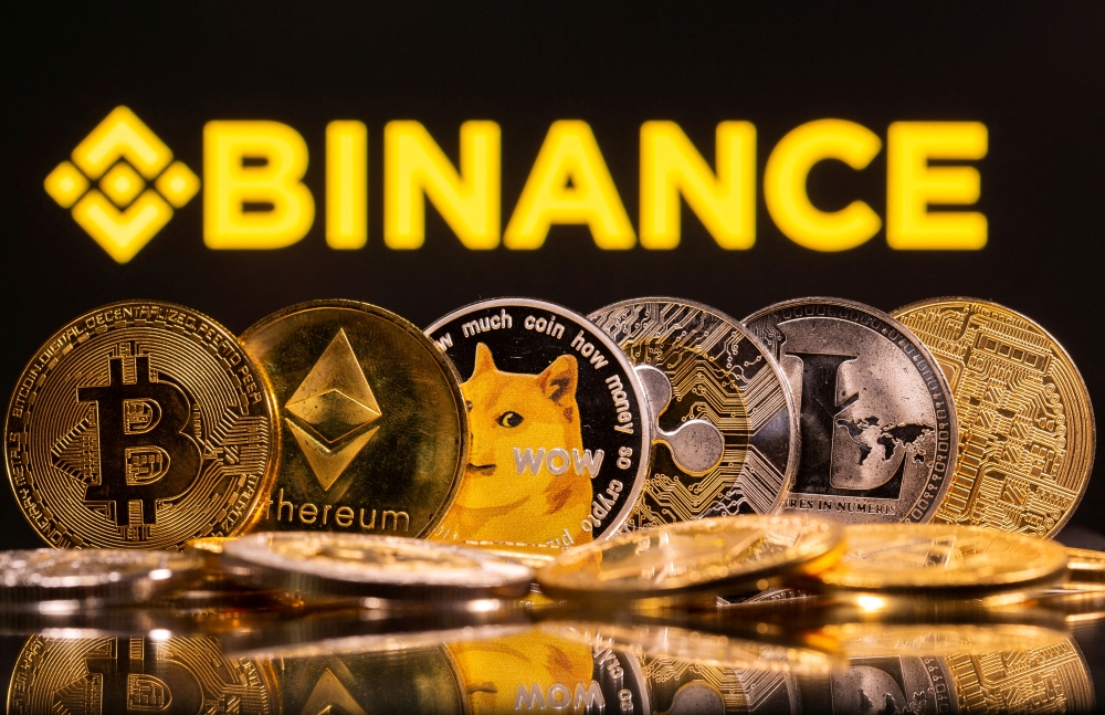 FILE PHOTO: Representations of cryptocurrencies Bitcoin, Ethereum, DogeCoin, Ripple, and Litecoin are seen in front of a displayed Binance logo in this illustration taken, June 28, 2021. REUTERS/Dado Ruvic/Illustration