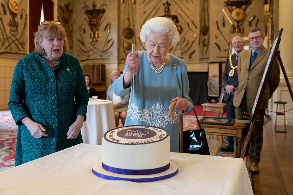 Britain's Queen Elizabeth II cuts a cake to celebrate the start of the Platinum Jubilee during a reception in the Ballroom of Sandringham House, which is the Queen's Norfolk residence, in Sandringham, Britain February 5, 2022. Joe Giddens/Pool via Reuters