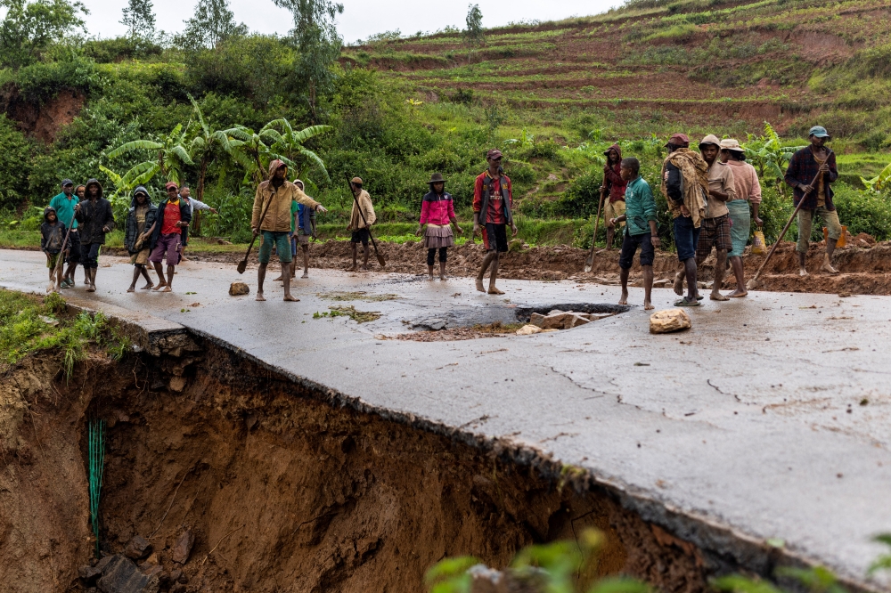 Locals stand on a damaged road following a landslide, as Cyclone Batsirai hits Madagascar, in Haute Matsiatra region, Madagascar, February 6, 2022. REUTERS/Alkis Konstantinidis