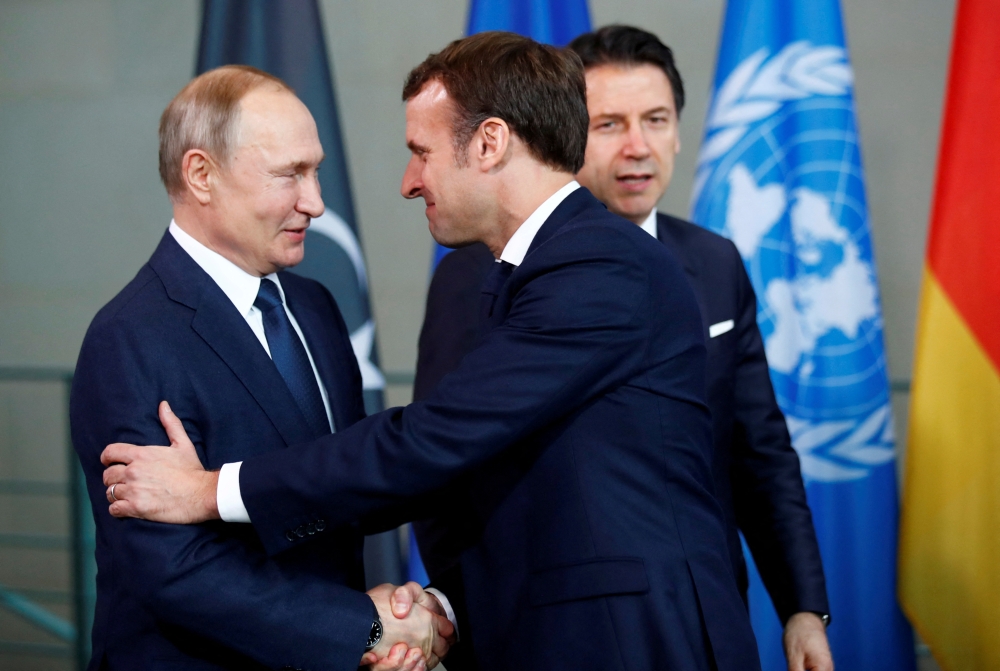 FILE PHOTO: Russian President Vladimir Putin shakes hands with French President Emmanuel Macron during the Libya summit in Berlin, Germany, January 19, 2020. REUTERS/Hannibal Hanschke