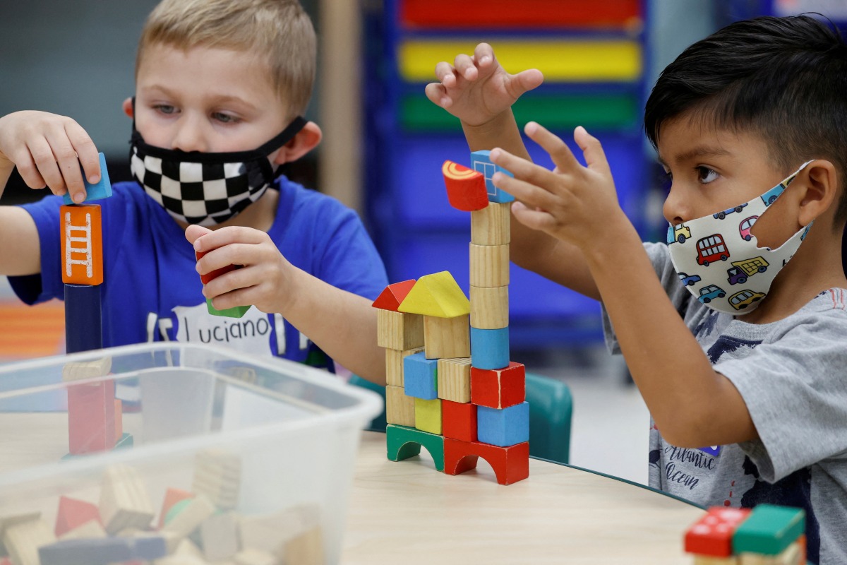 FILE PHOTO: Children wear a masks and wait for U.S. President Joe Biden to visit her pre-Kindergarten class at East End Elementary School to highlight the early childhood education proposal in his Build Back Better infrastructure agenda in North Plainfield, New Jersey, U.S. October 25, 2021. REUTERS/Jonathan Ernst/File Photo
