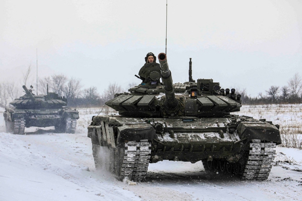 Russian servicemen drive tanks during military exercises in the Leningrad Region, Russia, in this handout picture released February 14, 2022. Russian Defence Ministry/Handout via REUTERS