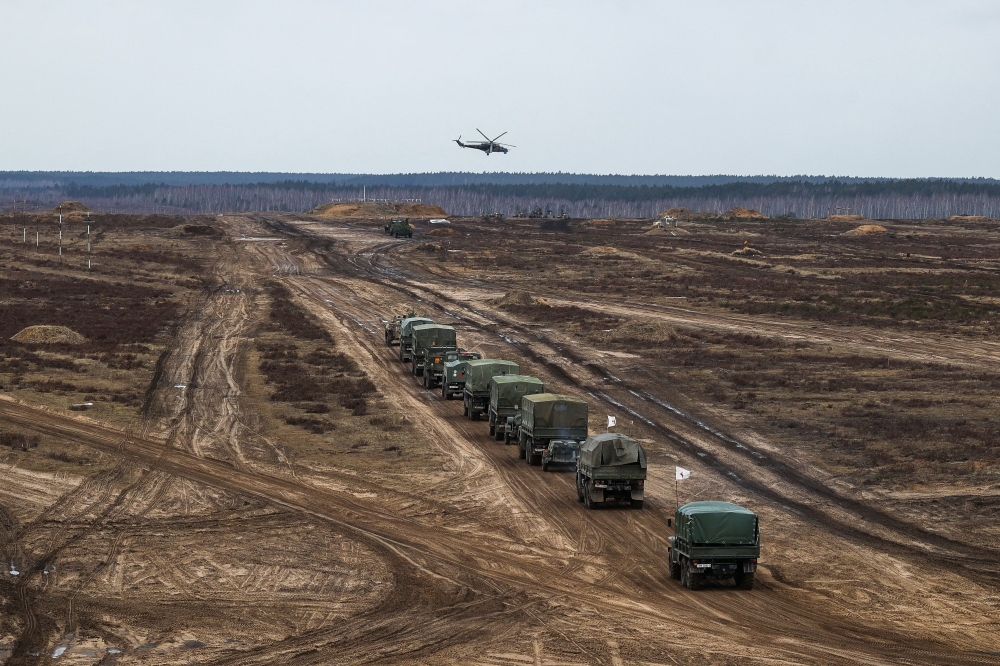 A helicopter flies over troops during the joint military drills of the armed forces of Russia and Belarus at a firing range in the Brest Region, Belarus February 19, 2022. 